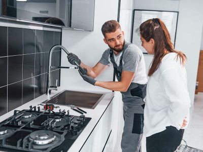 young-professional-plumber-in-grey-uniform-shows-r-resize.jpg